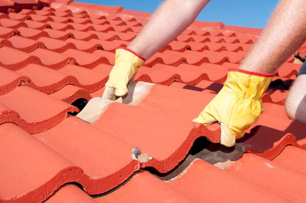 Roofer repairing tiled roof