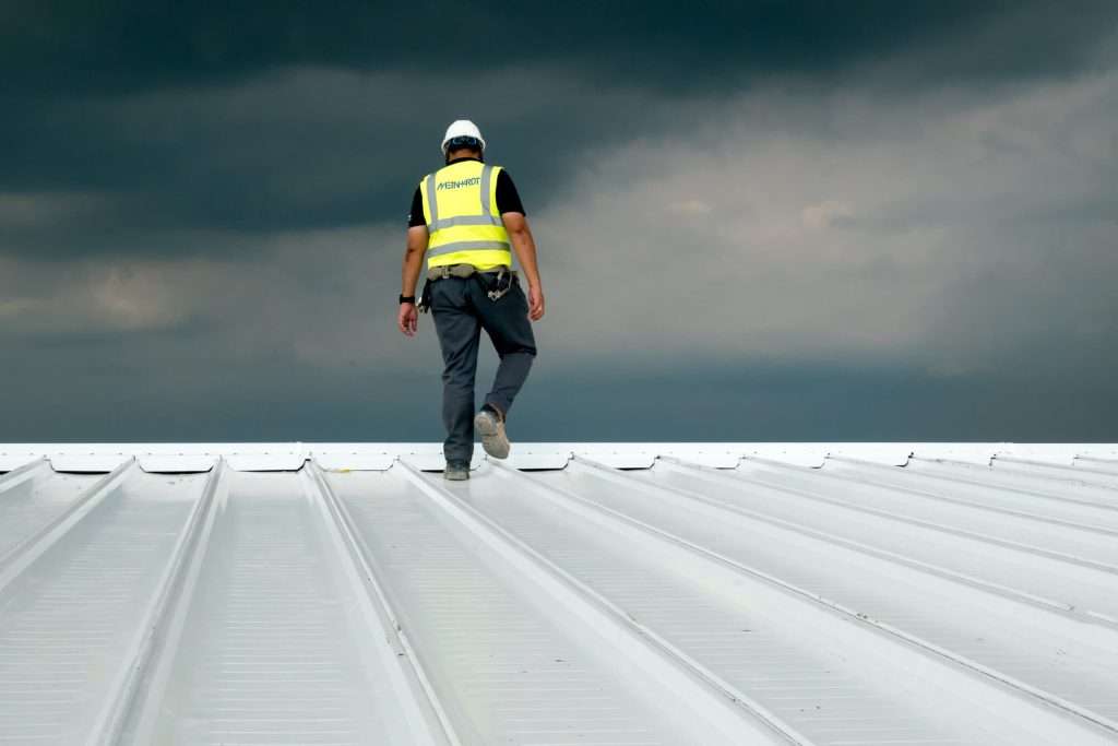 Roofer inspecting metal roof